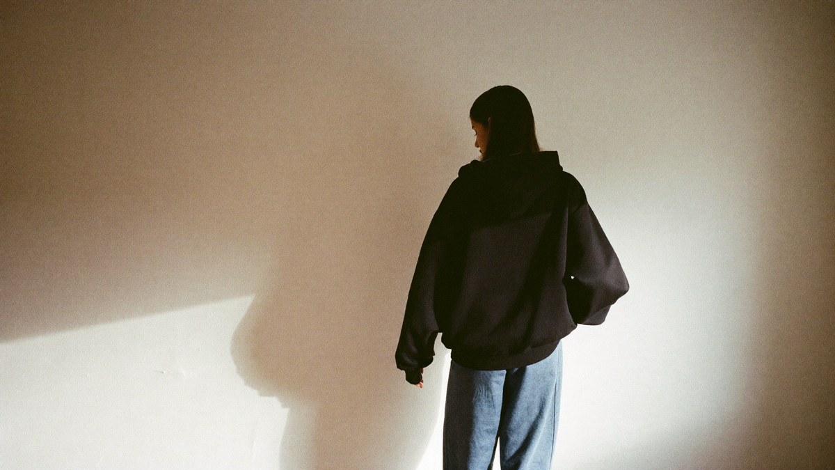 A quiet moment in an unbranded hoodie, in warm afternoon light