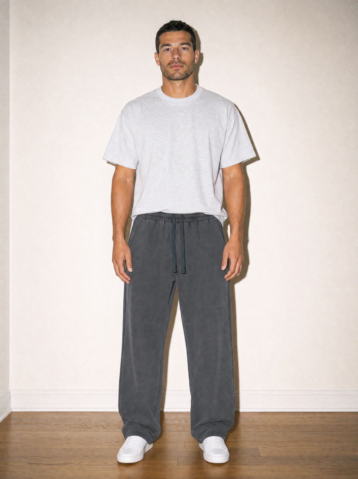 Home & Away Sweatpant in Dark Gray, front view, worn against the apartment wall: 420 gsm heavyweight cotton knit with a vintage wash